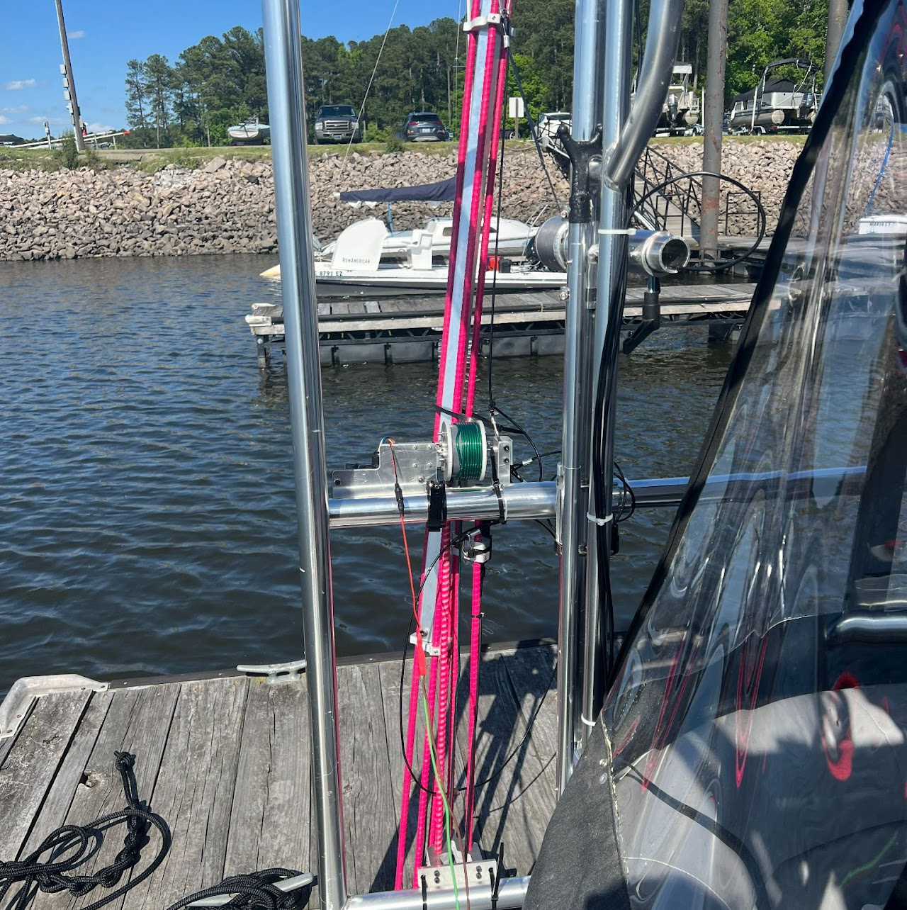 At a lake, on a docked boat, the testing device sits attached to metal rails running along the side of the boat.