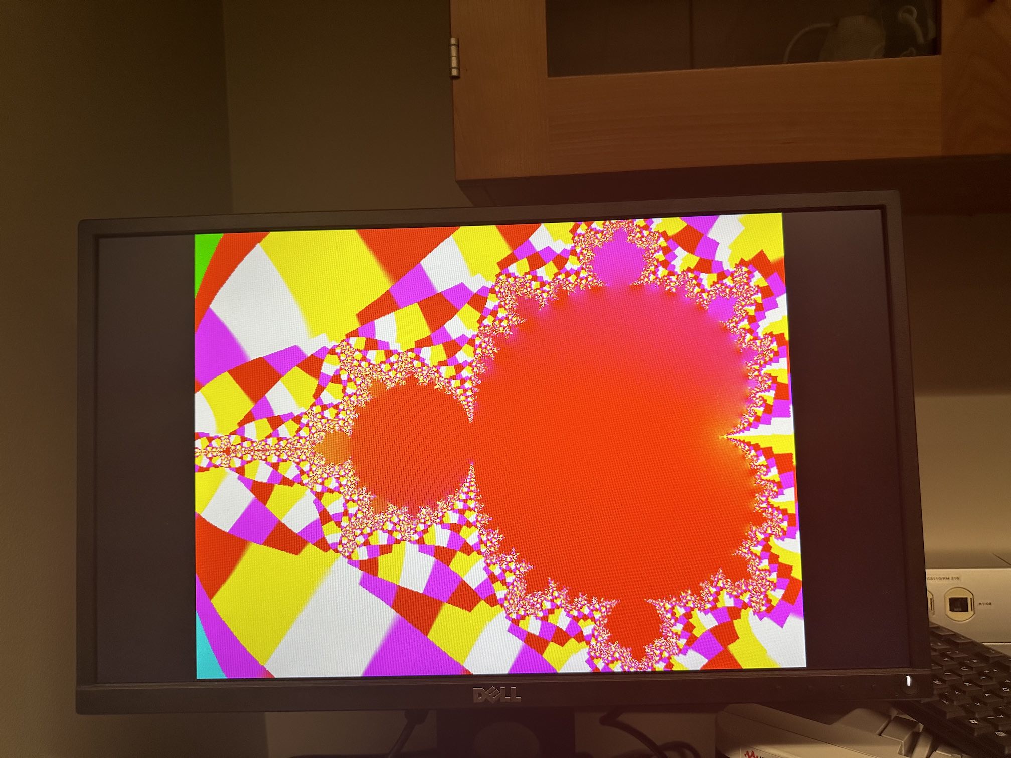 The mandelbrot set with a red, pink, white, and yellow color scheme tiling the outside of the set.