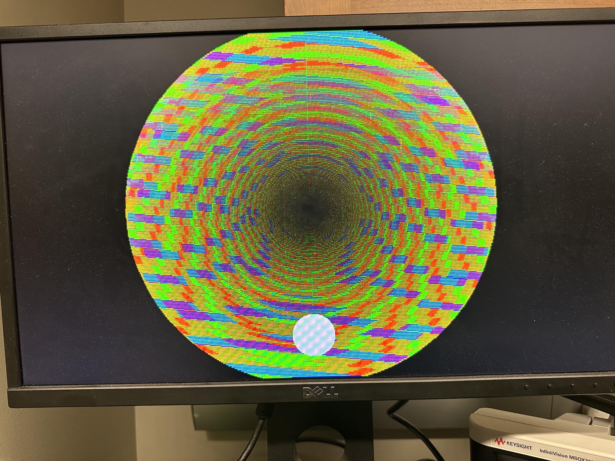 A monitor a circle with streaks of red, green, and blue.